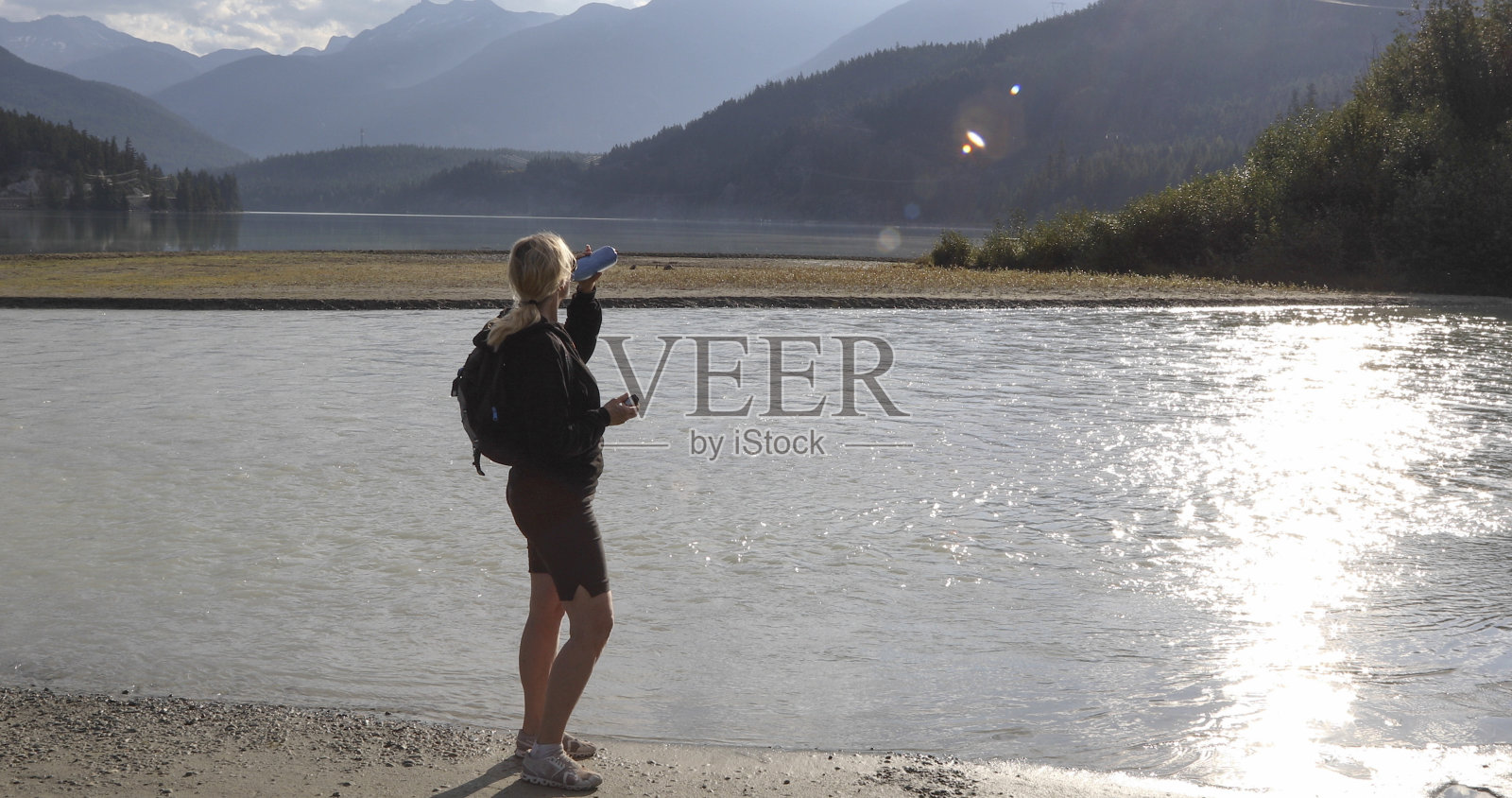 日出时分，女人在湖边休息照片摄影图片