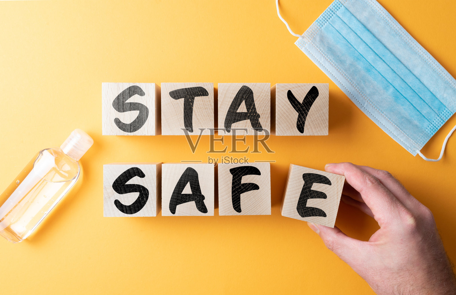 用防护口罩和洗手液在橙色背景的木块上保持安全照片摄影图片