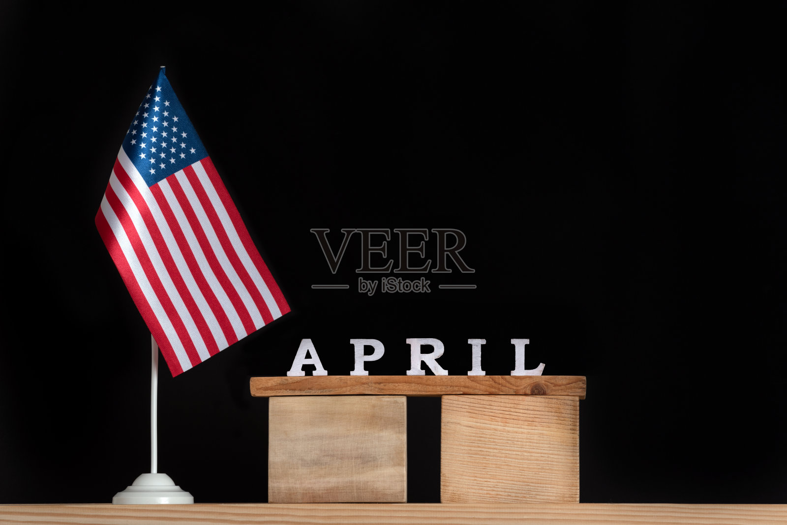 木制的四月日历与美国国旗在黑色的背景。美国四月的节日。照片摄影图片