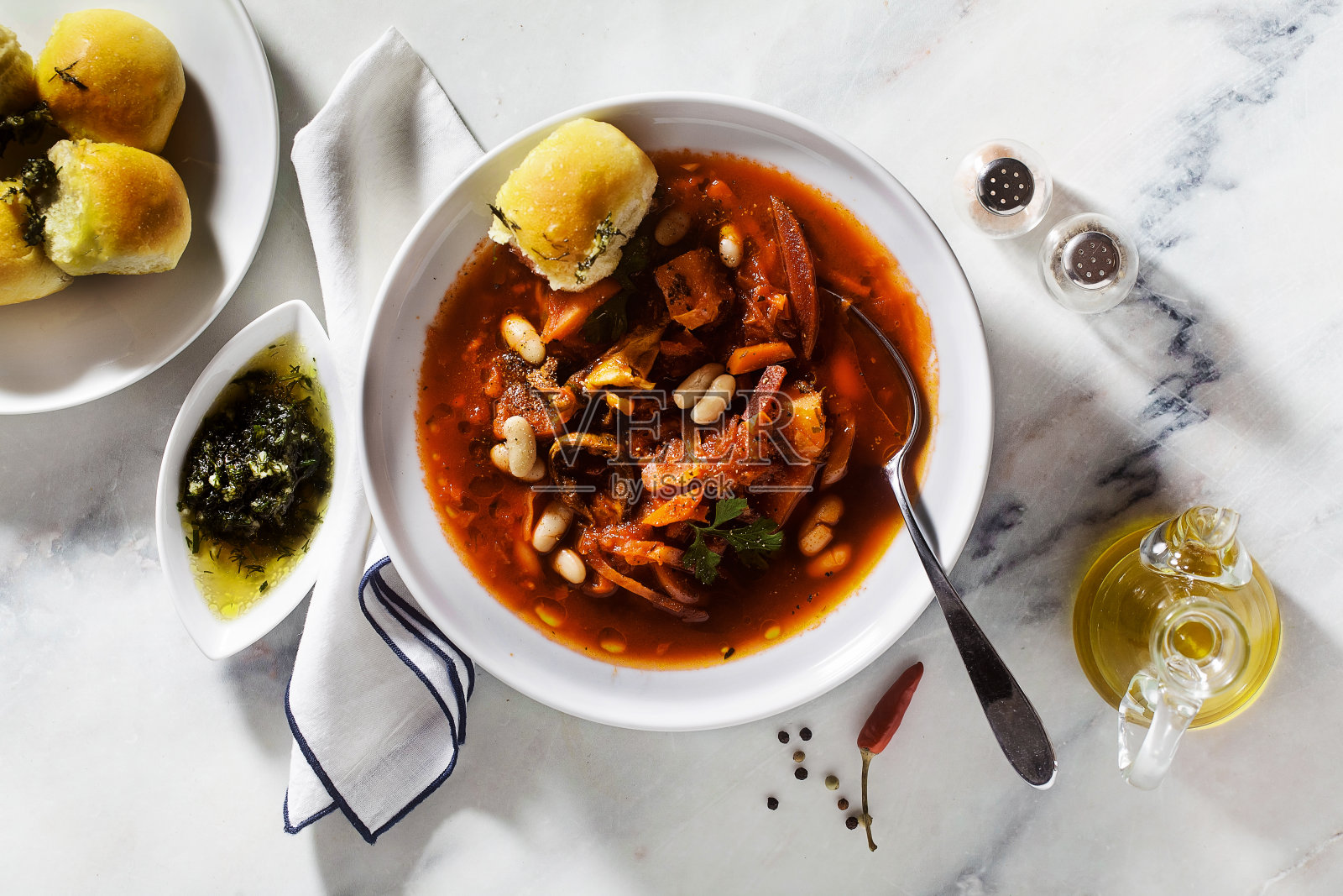 大理石桌子上的乌克兰罗宋汤、蘑菇、白豆和pampushki面包照片摄影图片