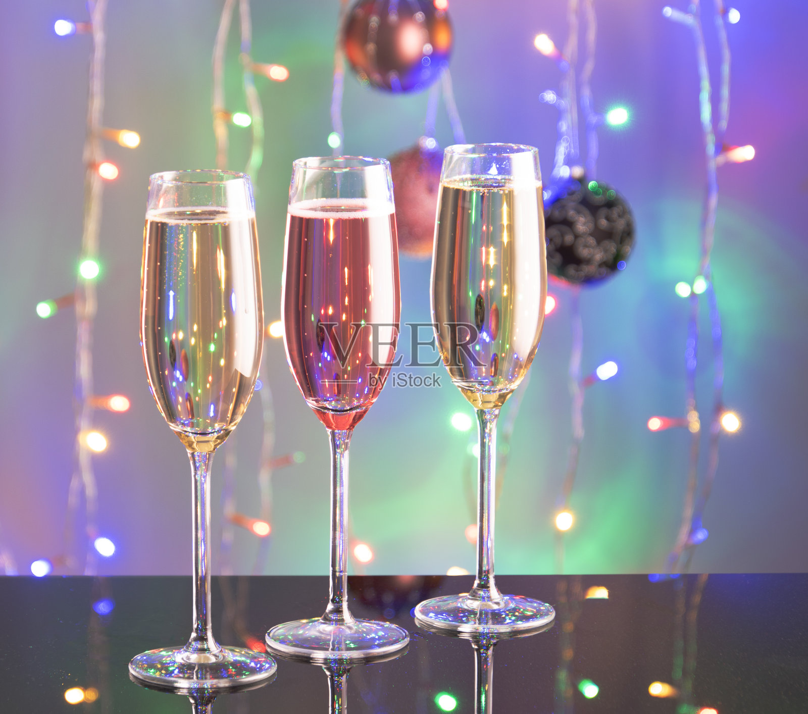 三杯香槟，背景是灯光。照片摄影图片