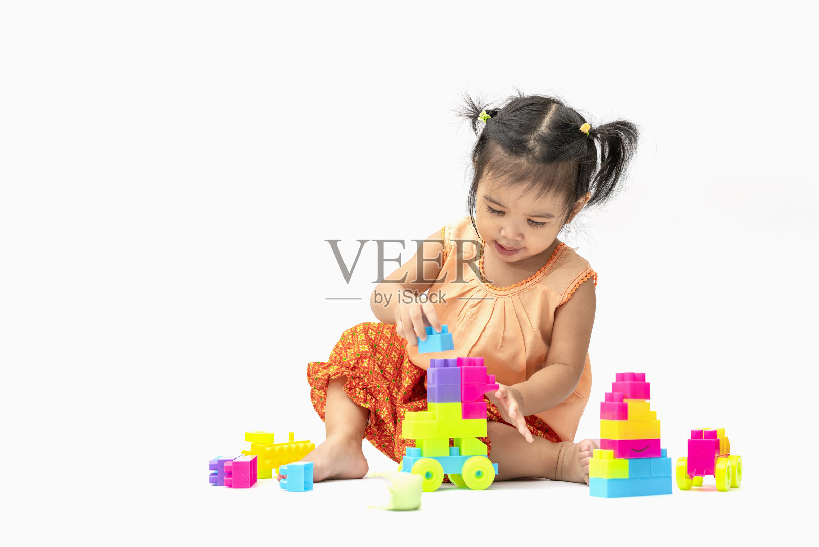 亚洲儿童女孩在泰国传统服装坐和玩彩色塑料块或玩具愉快地孤立在白色背景照片摄影图片