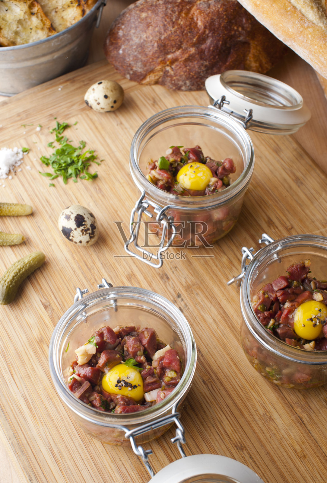 牛排或鞑靼牛肉。鞑靼牛排。经典的美国餐厅或法国小酒馆开胃菜经典。牛排切丁，混合鸡蛋，红洋葱，橄榄油，柠檬汁，大蒜和酸豆。配上蒜蓉面包。照片摄影图片