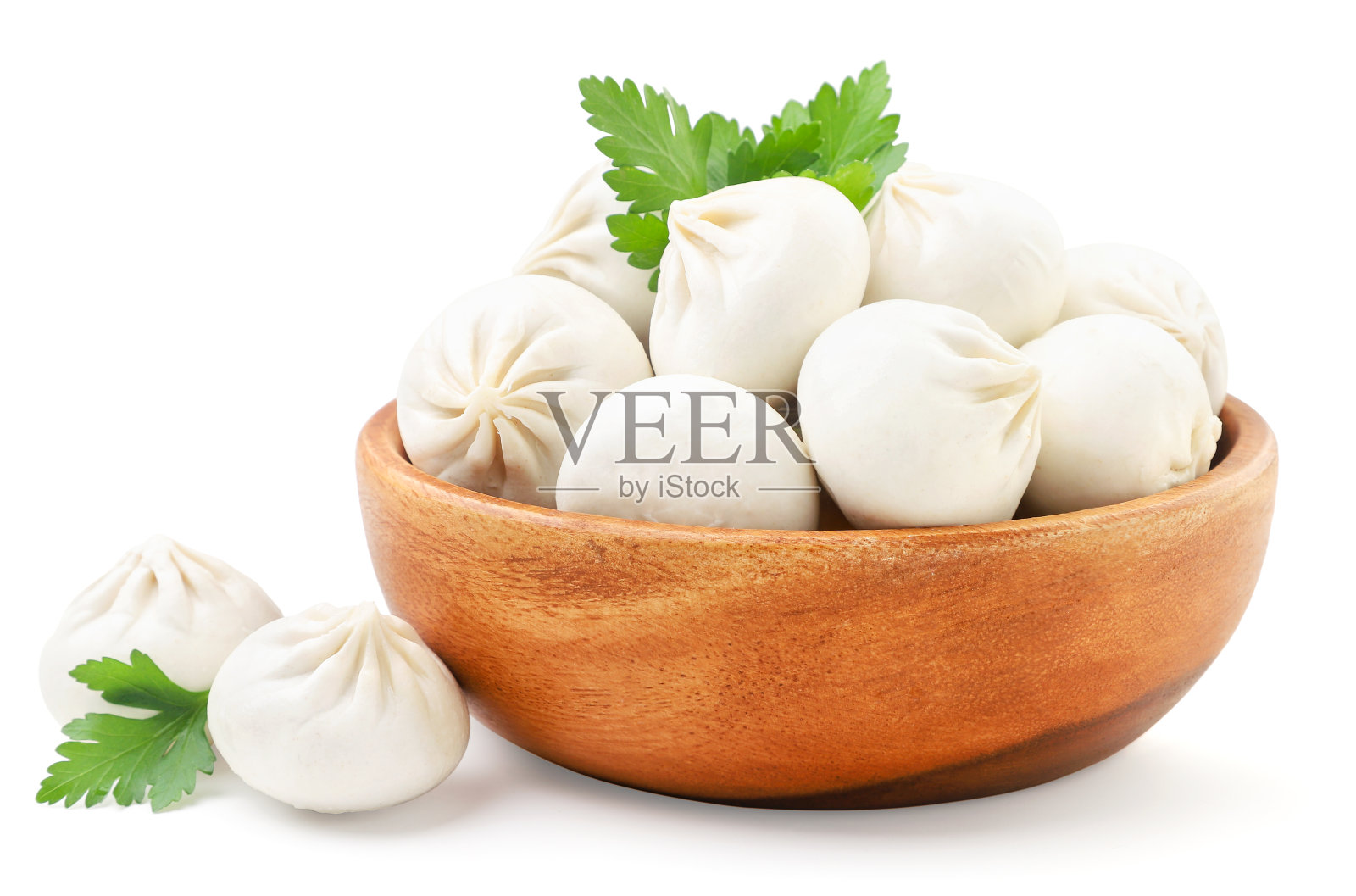 在一个白色的盘子里与香草一起煮khinkali。孤立的照片摄影图片