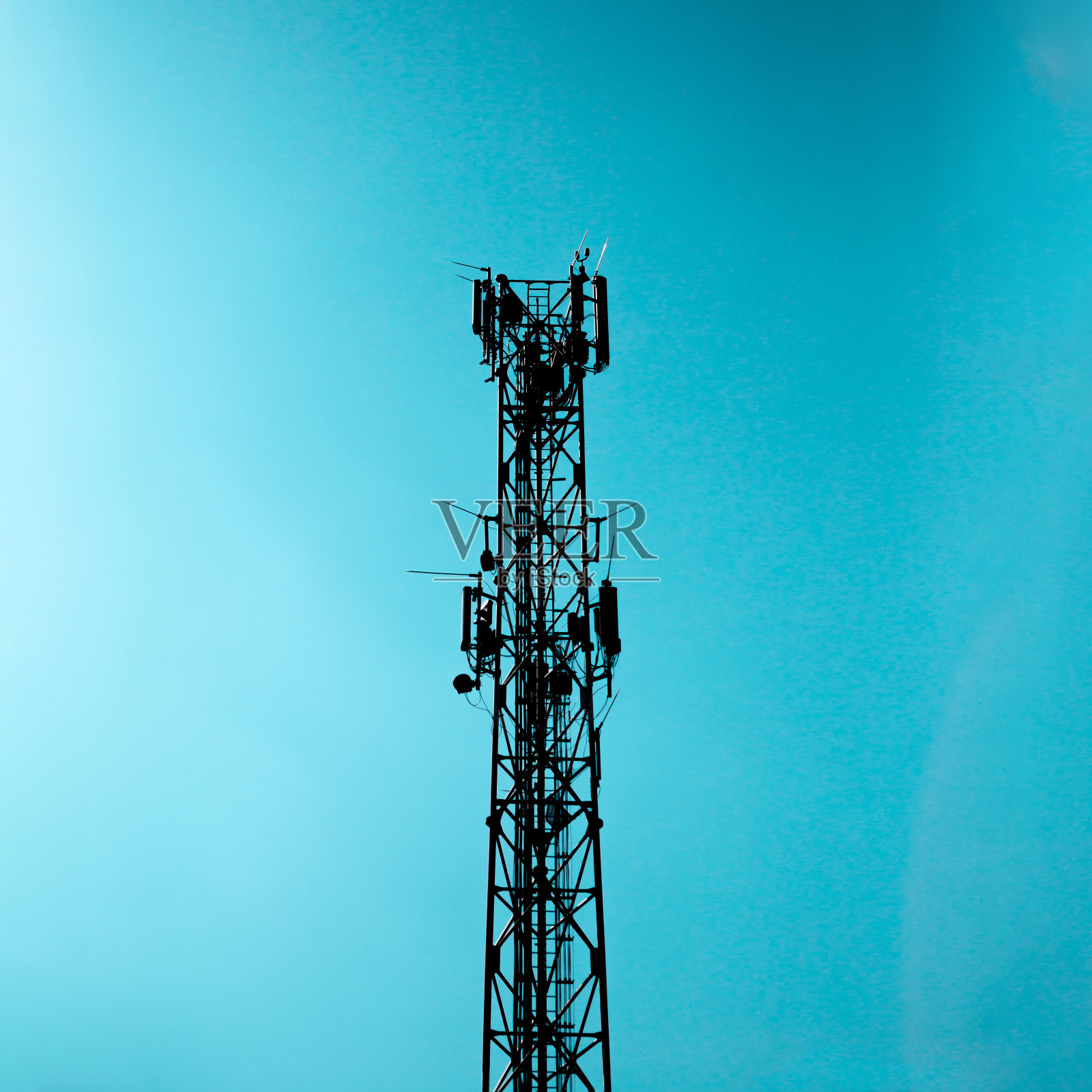 用于移动电话和互联网的无线电信号塔。塔是由金属结构，后面是蓝天。照片摄影图片