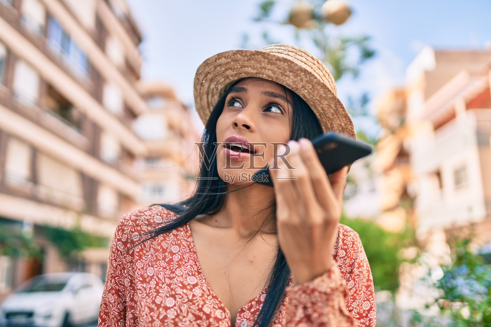 年轻的非洲裔美国女游客在度假时用智能手机发送语音信息。照片摄影图片