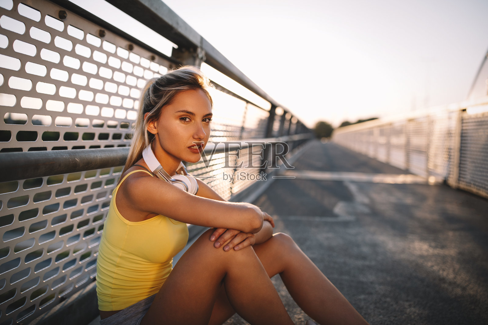 一幅健康愉快的金发女子在城市跑步后休息的肖像照片摄影图片