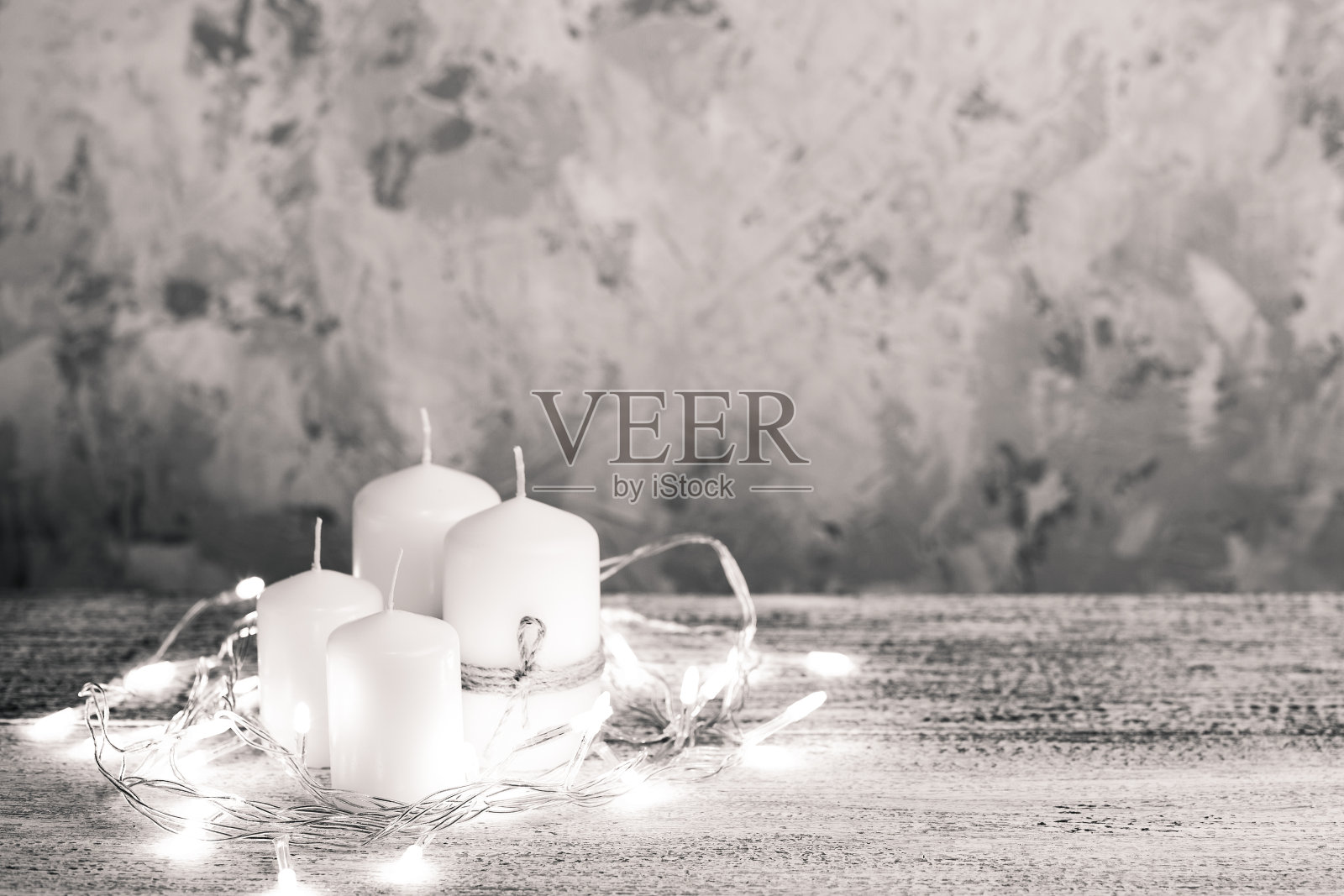 四个不同大小的白色蜡烛的模型花环放在木桌上照片摄影图片