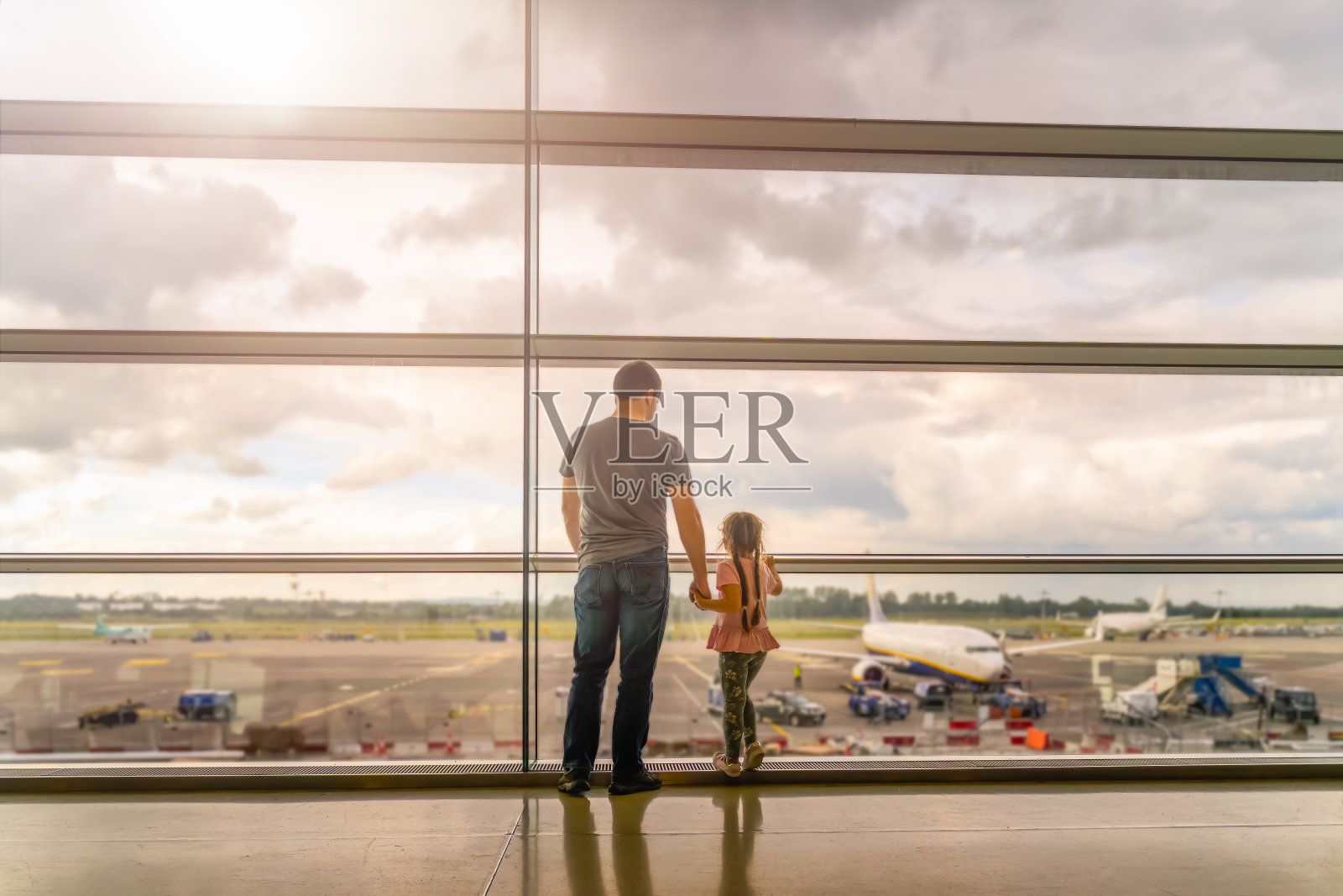 年轻的家庭，父亲和女儿在机场航站楼的剪影照片摄影图片