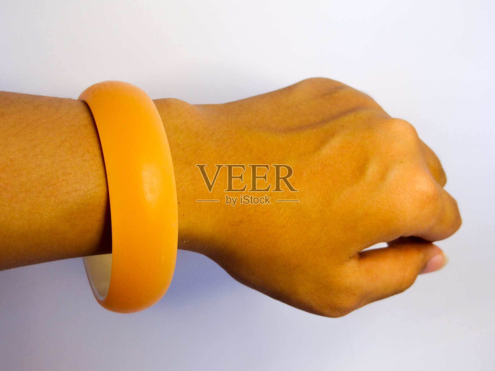 手镯在橙色的手在白色的背景照片摄影图片