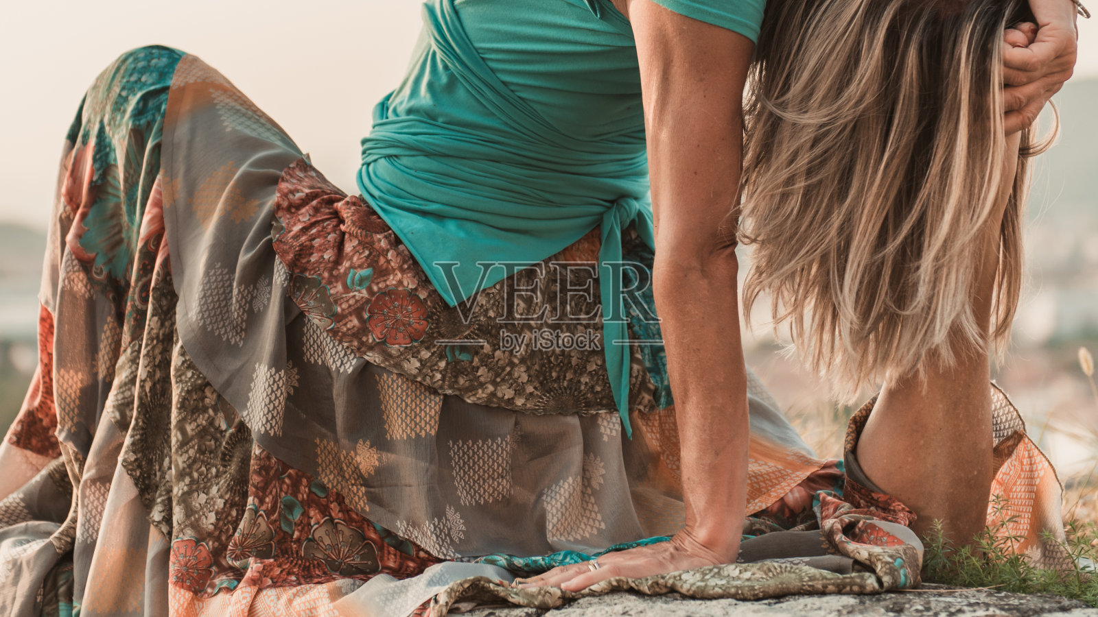 成年妇女进行体育锻炼。瑜伽老师在老城墙上做体式。照片摄影图片