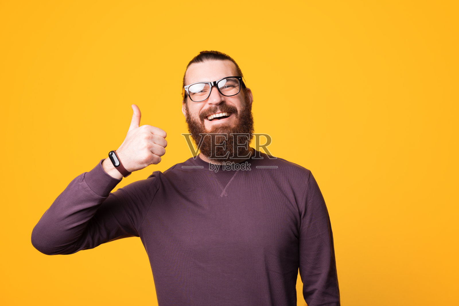 一个戴着眼镜，满脸胡子的年轻人对着镜头微笑，竖起大拇指照片摄影图片