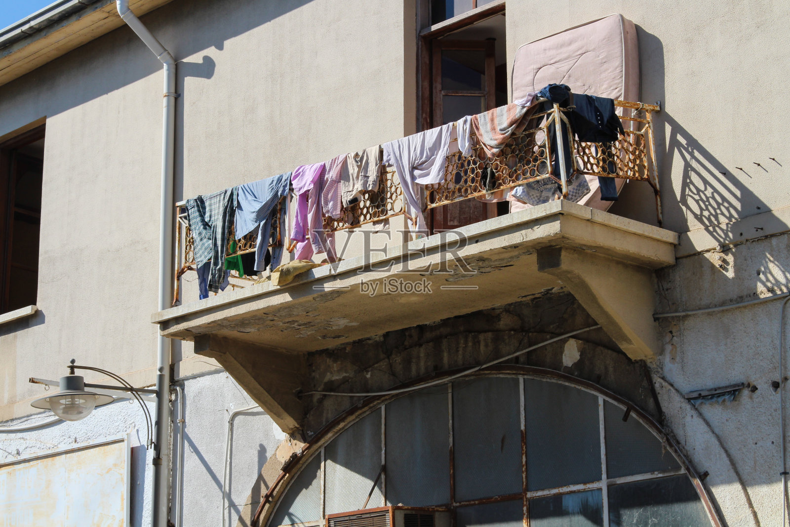 镂空的铸铁阳台，挂着晾干的亚麻布，在法玛古斯塔的一条街上。塞浦路斯。照片摄影图片