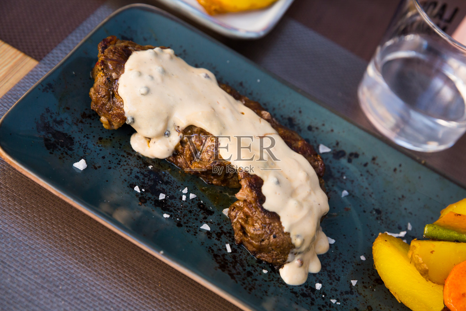 美味的小牛肉配辣椒酱和烤土豆在盘子里照片摄影图片