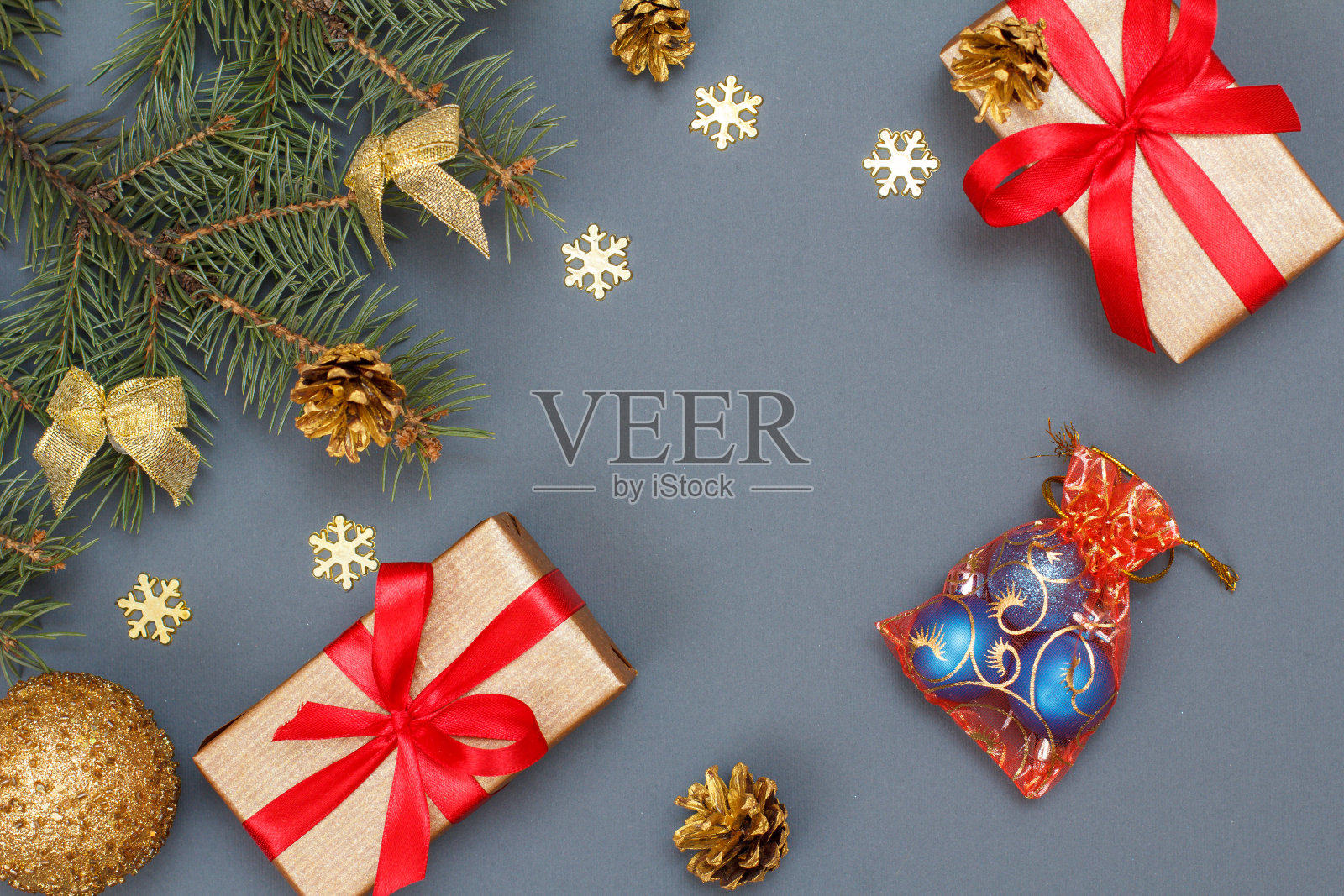 礼盒，带有锥形的冷杉树枝和灰色背景的圣诞玩具照片摄影图片