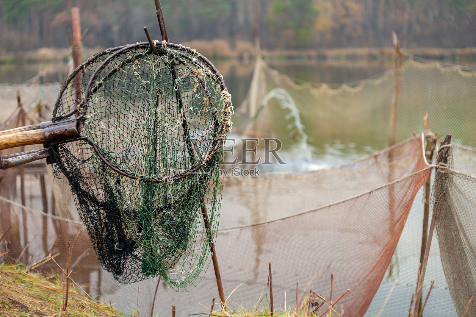 渔具如渔网和浸网，以森林湖为背景照片摄影图片