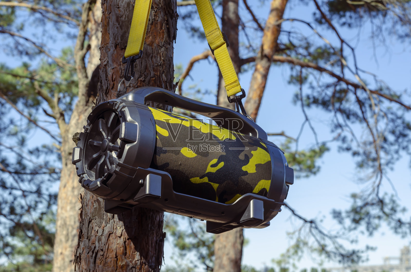 户外便携式低音炮无线蓝牙扬声器大悬挂在森林的树上。照片摄影图片