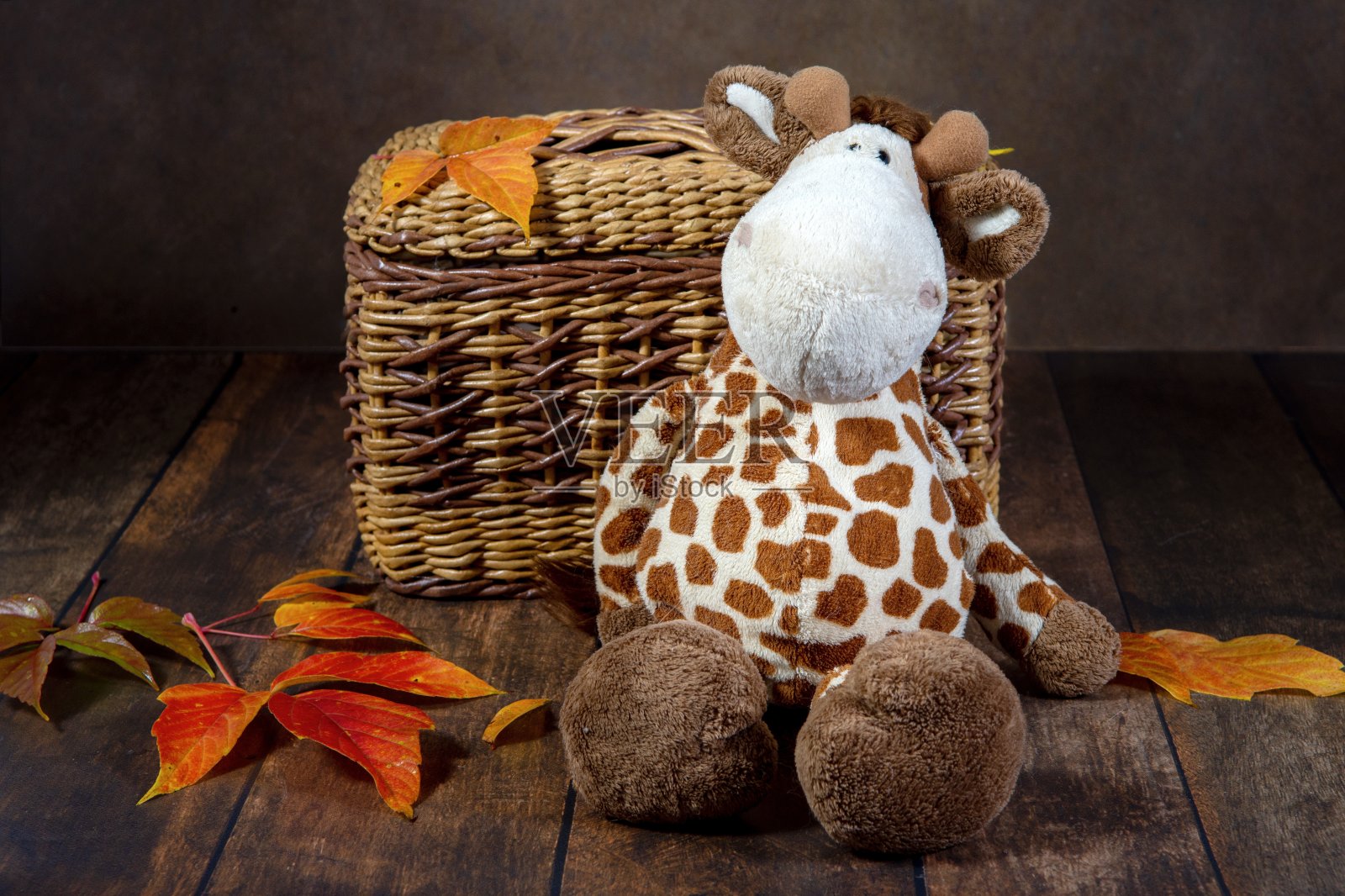 柳条盒子与儿童玩具长颈鹿在一个黑暗的背景照片摄影图片