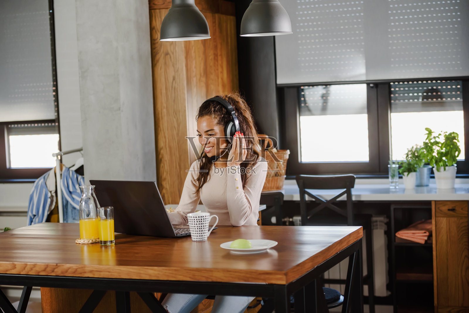 年轻的商业女性在家工作，坐在笔记本电脑前通过互联网开会。女人自由企业家。照片摄影图片
