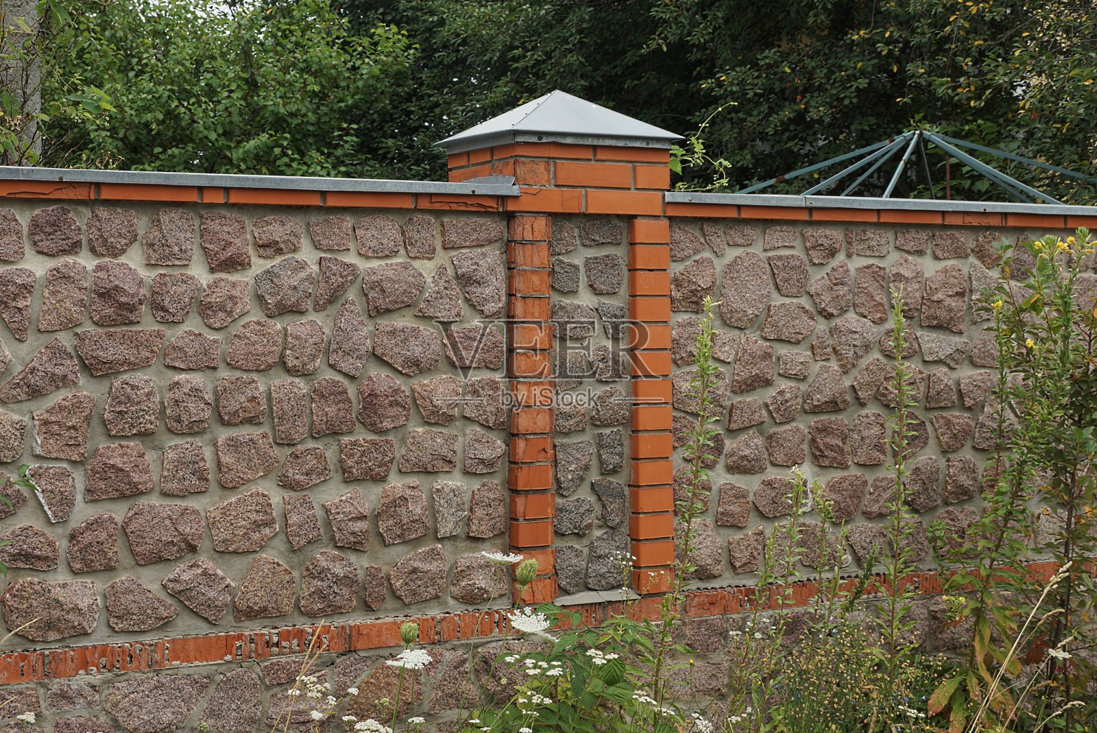 用砖块和石头砌成的棕色围墙的一部分照片摄影图片