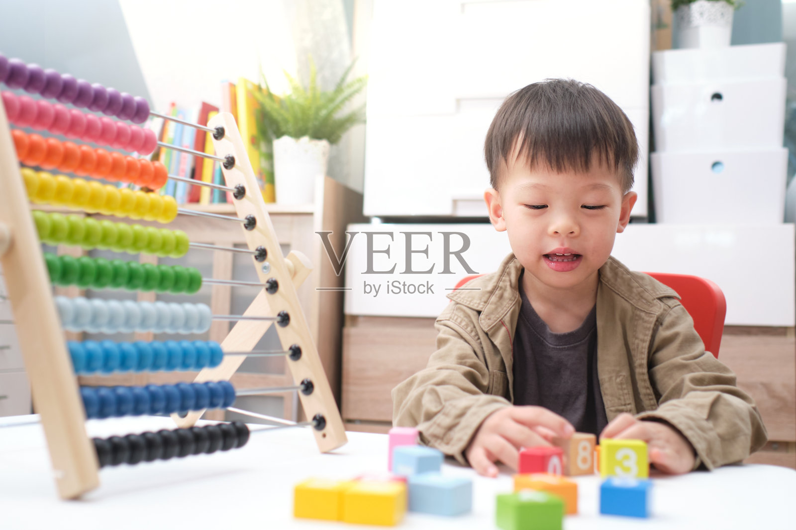 可爱的小亚洲人使用算盘与珠子和木砖与数字学习如何在家里，使用算盘教孩子数学概念照片摄影图片