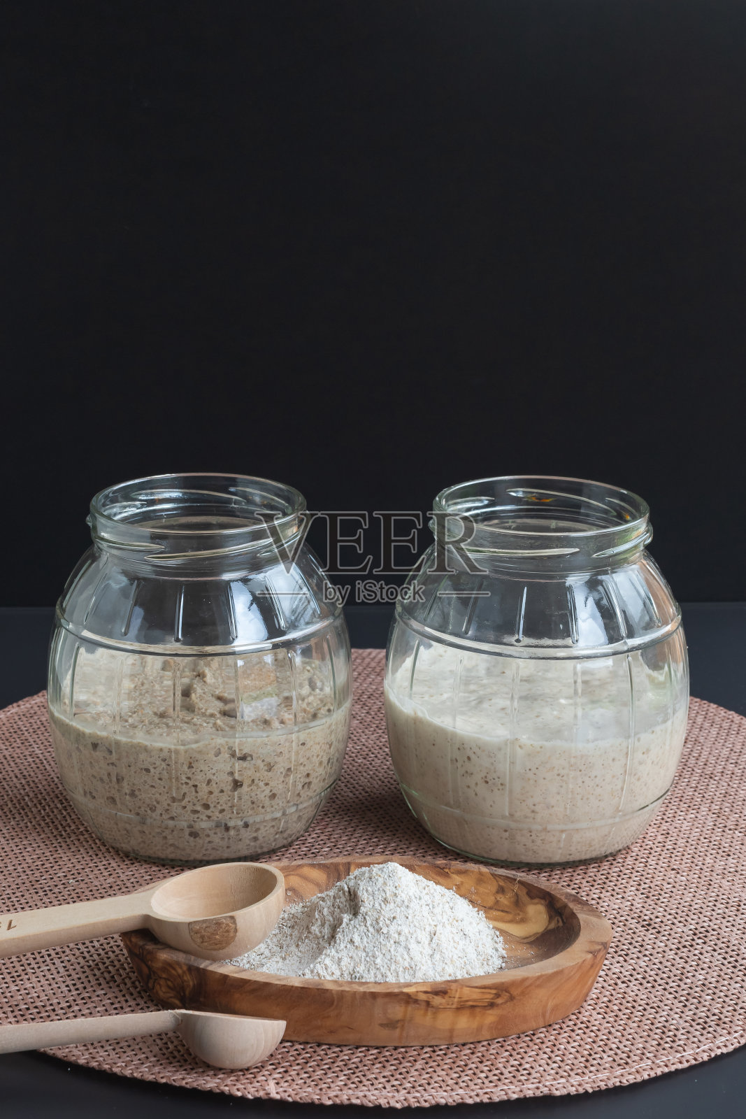 玻璃罐中新鲜发酵的黑麦和小麦发酵剂照片摄影图片