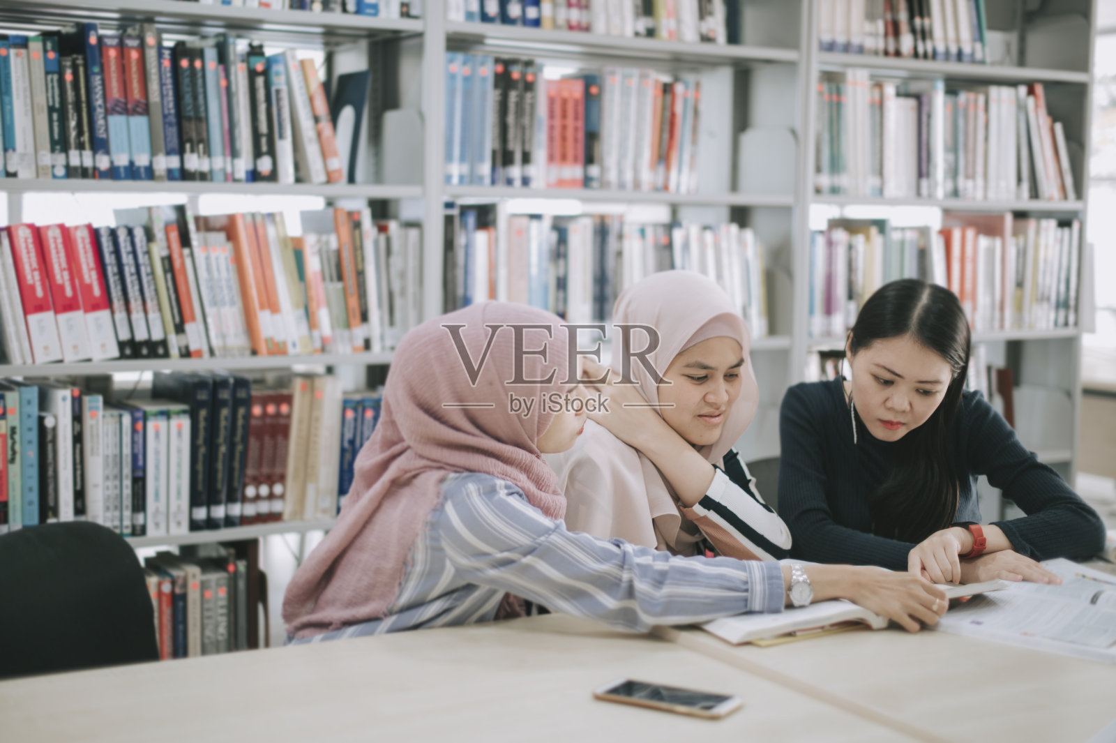 在图书馆学习的亚洲大学生照片摄影图片