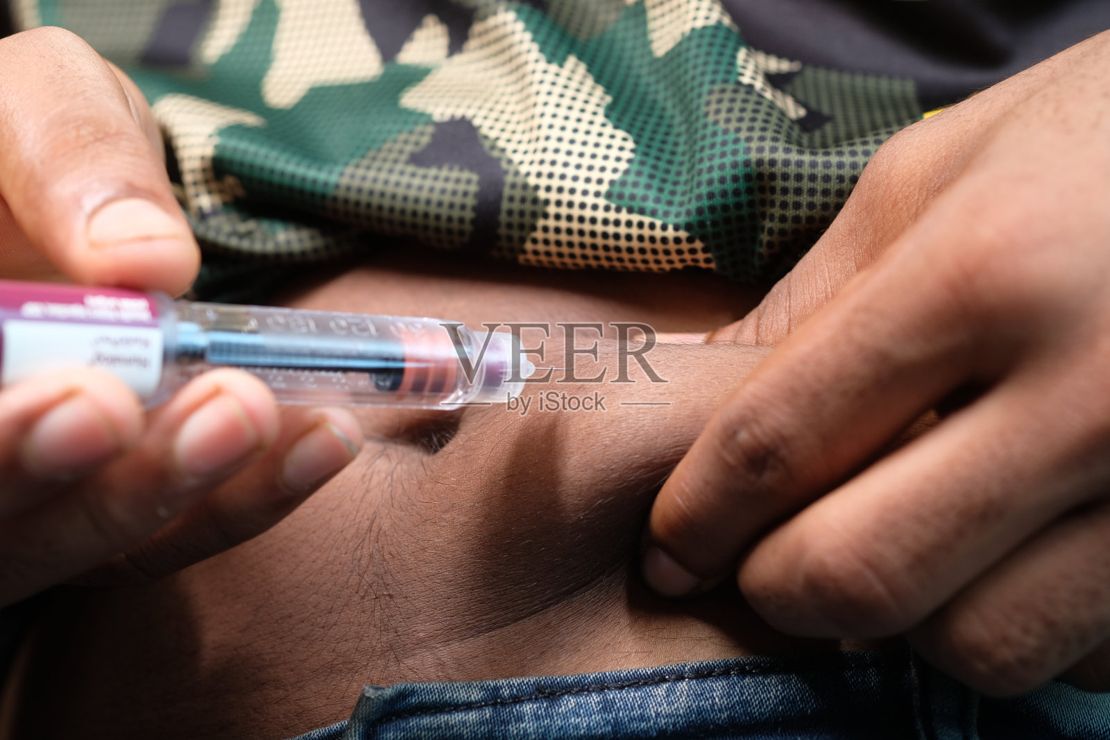 手握胰岛素笔靠近照片摄影图片