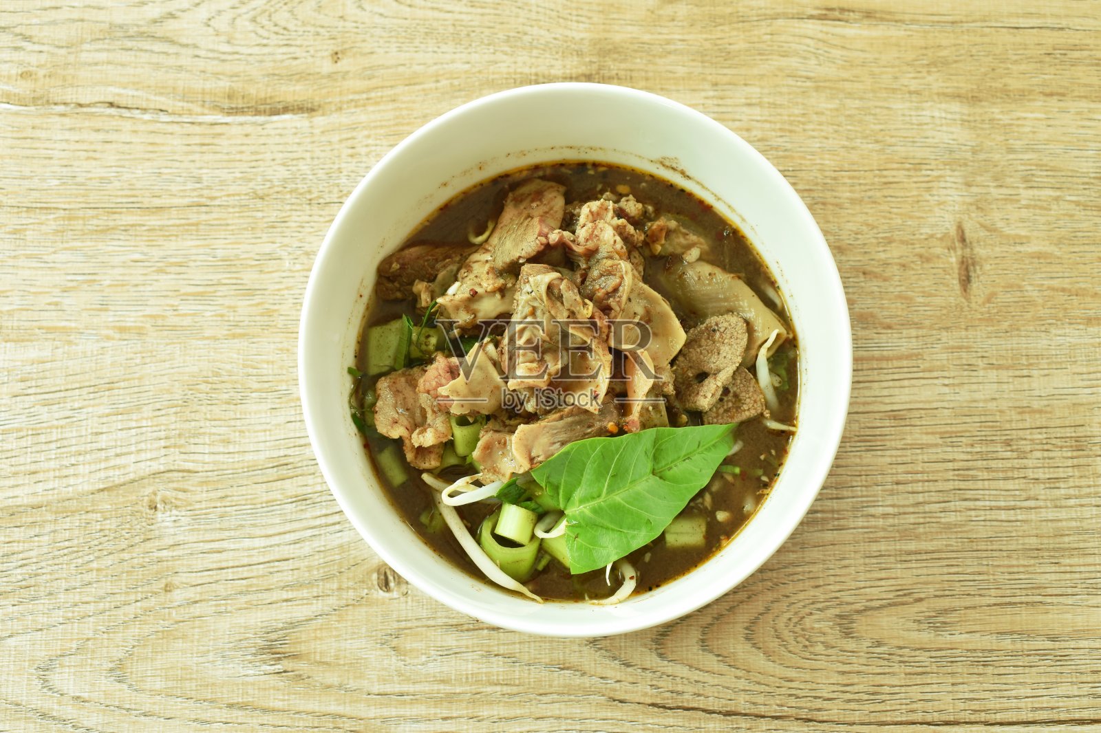 红烧猪肝和牵牛花在棕色香草汤照片摄影图片