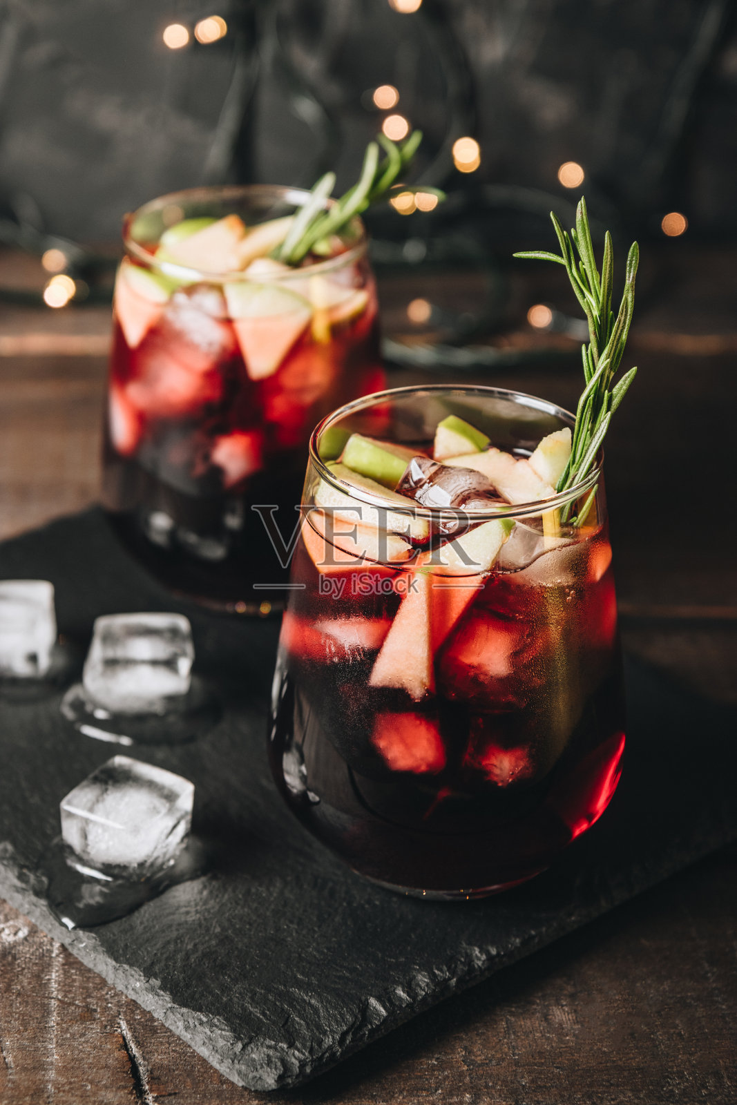 两杯加冰的桑格利亚汽酒。红酒配苹果和香料，垂直照片照片摄影图片