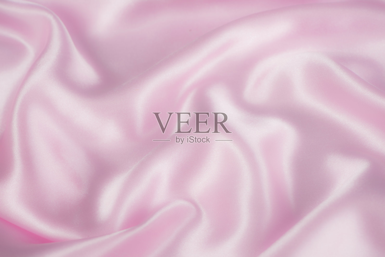 抽象的粉色织物纹理背景。布料柔软的波。缎子、丝绸的折痕照片摄影图片