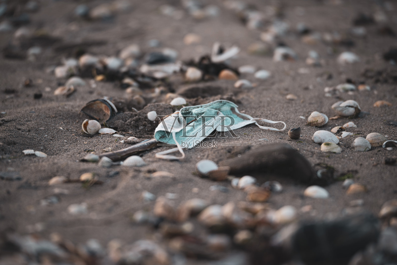 废弃的医用口罩被冲上海滩照片摄影图片