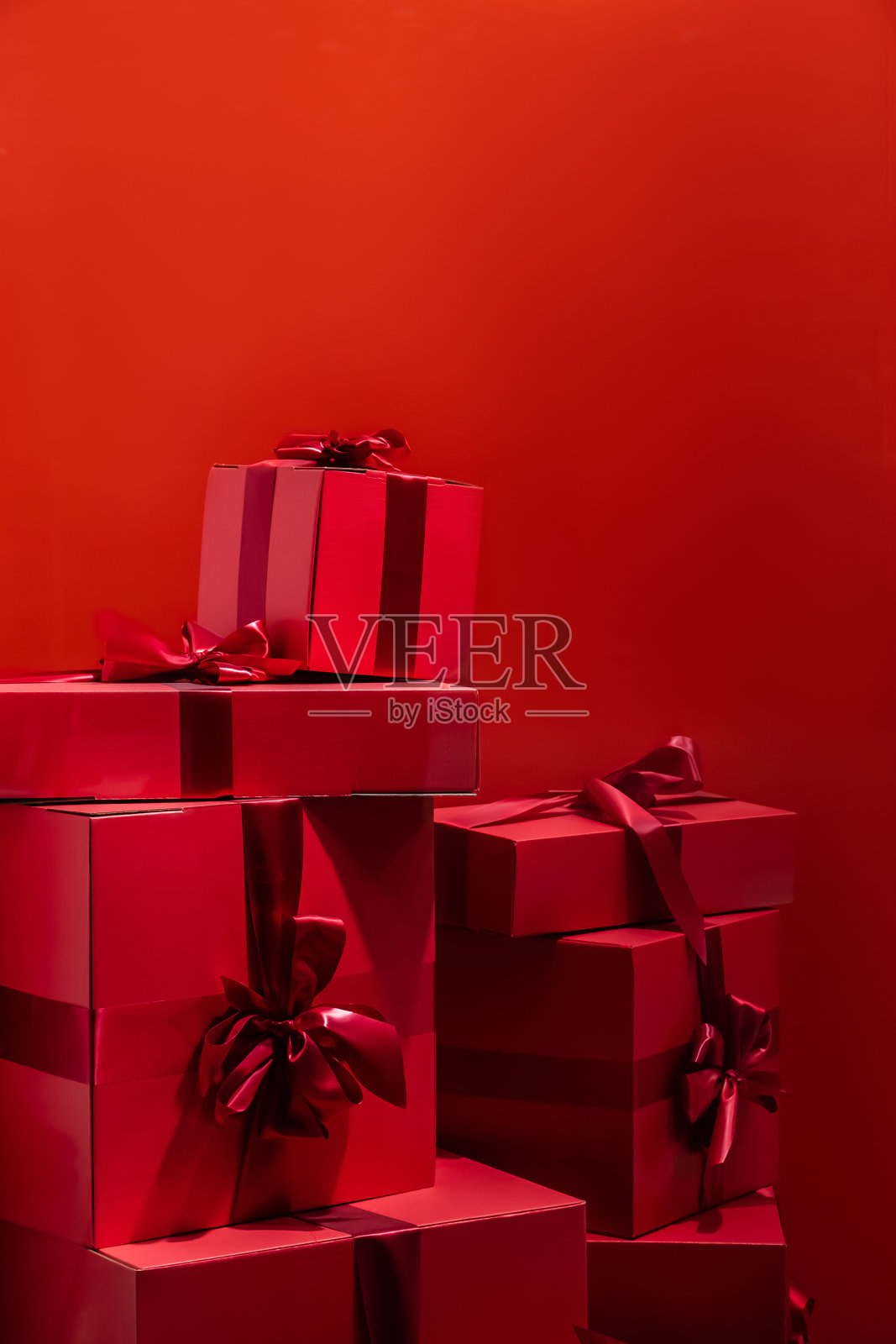 红色背景上有蝴蝶结的礼品盒。照片摄影图片