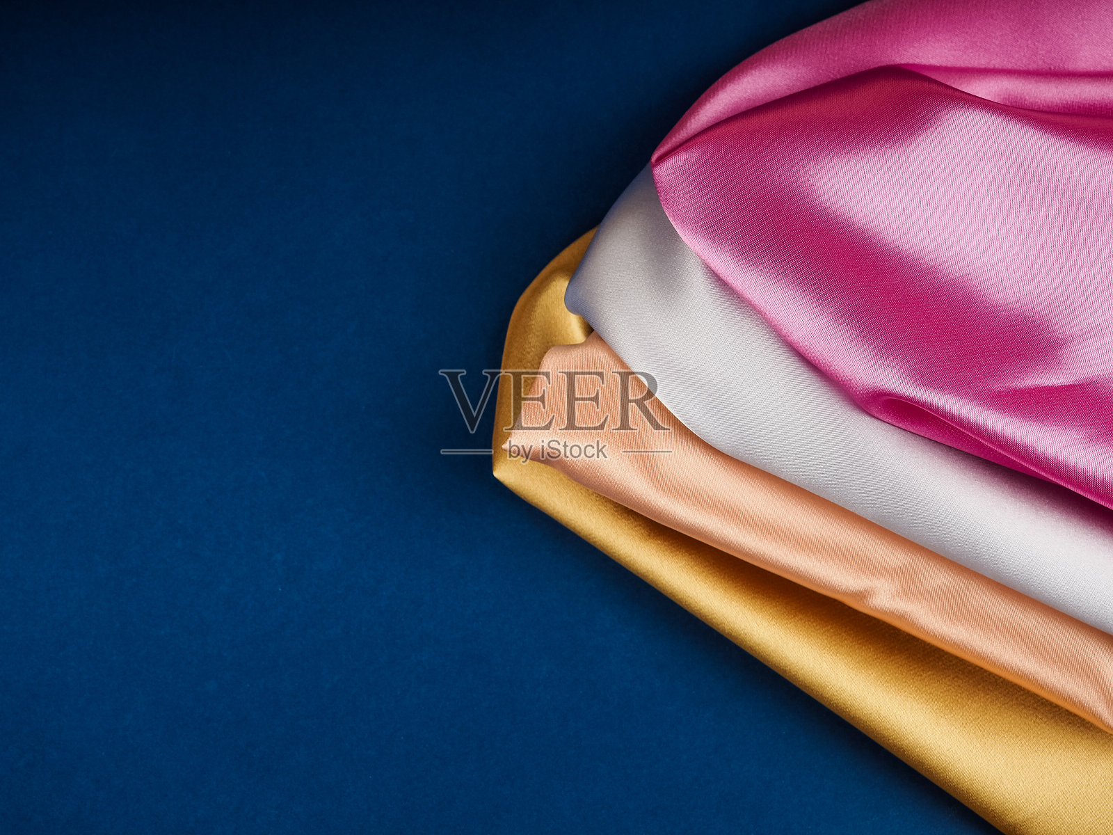 多色丝绸织物上的蓝色背景，文字空间，美丽的背景为明信片照片摄影图片
