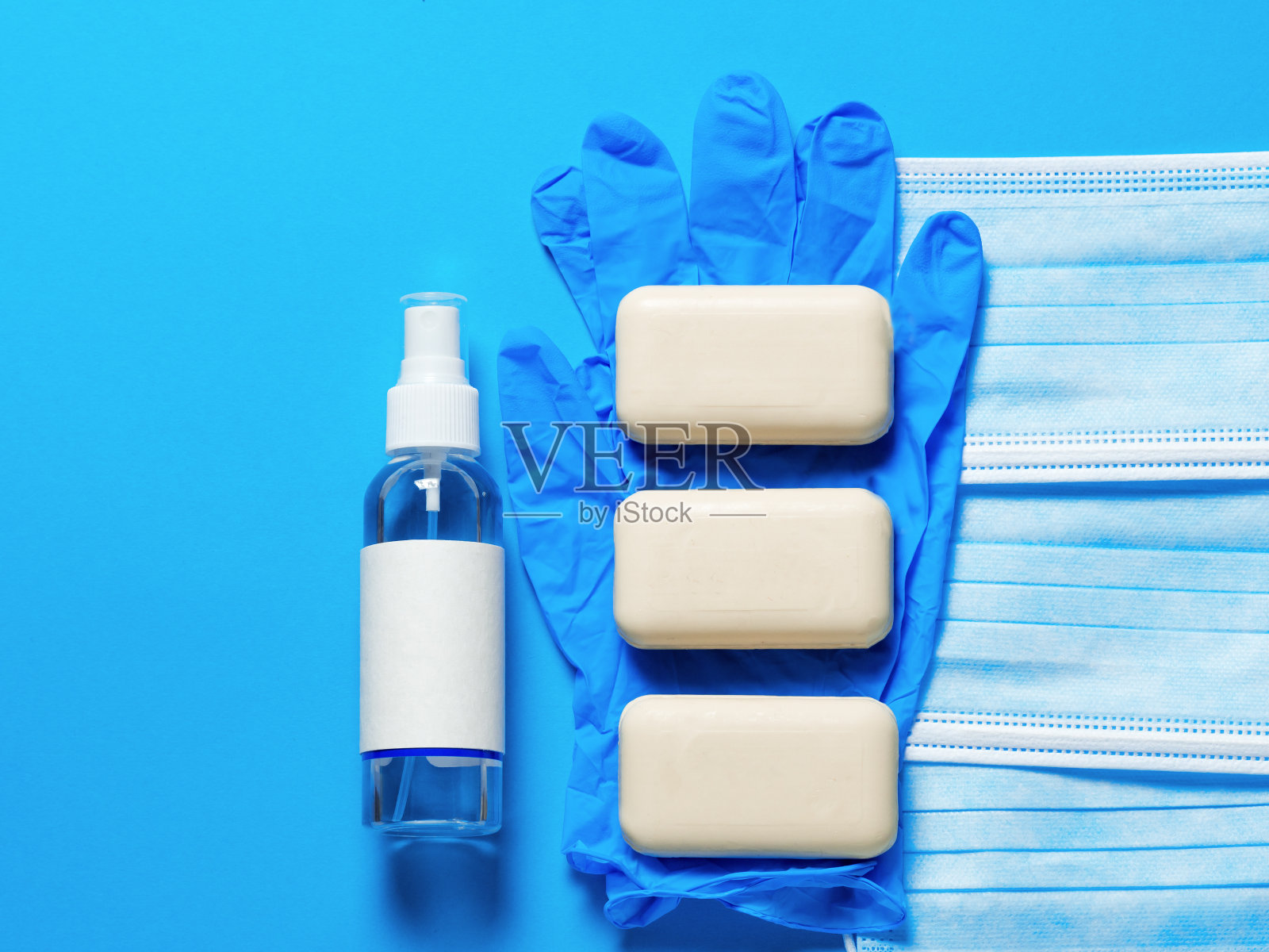 医用防护口罩，肥皂，洗手液，蓝色背景。个人一次性卫生设备。检疫卫生保健和冠状病毒防护理念。照片摄影图片