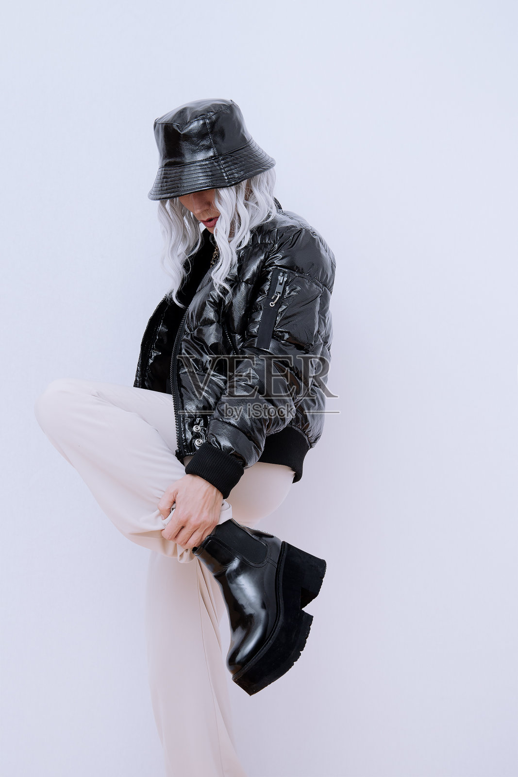 性感的金发模特在时尚的城市街道装。时髦的桶帽和轰炸机。魅力平台靴子。时尚的秋冬季节照片摄影图片