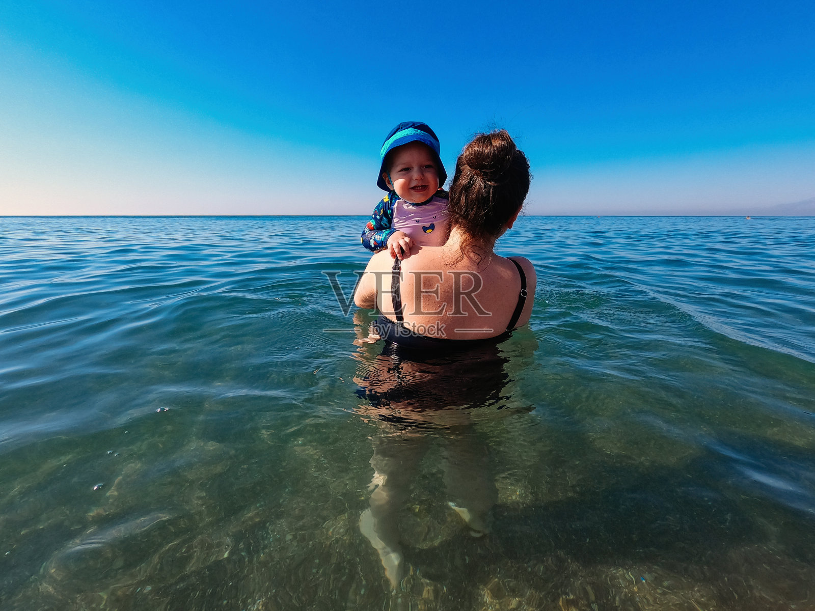 妈妈和儿子在海里玩得很开心照片摄影图片