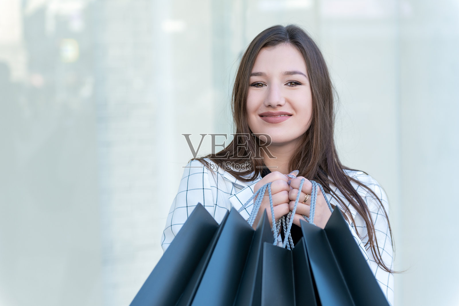 快乐的年轻女子的肖像与黑色购物袋。出售。近距离照片摄影图片