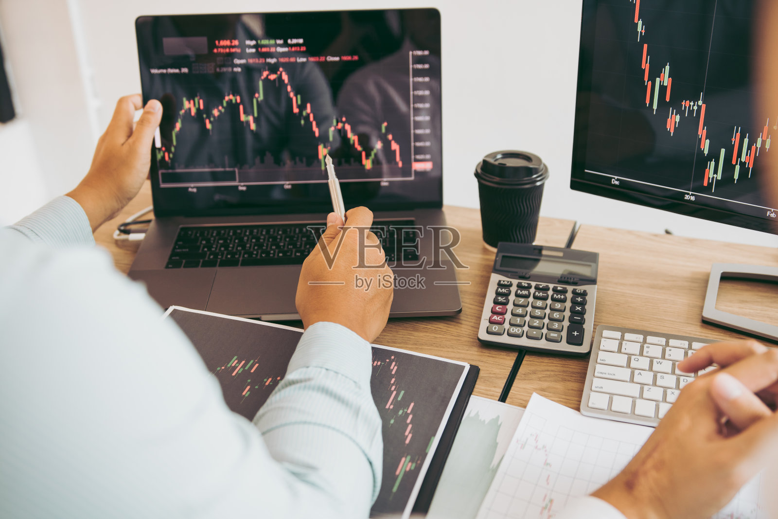 两个合伙投资者正在一起讨论，分析公司电脑屏幕上的股票图表。照片摄影图片