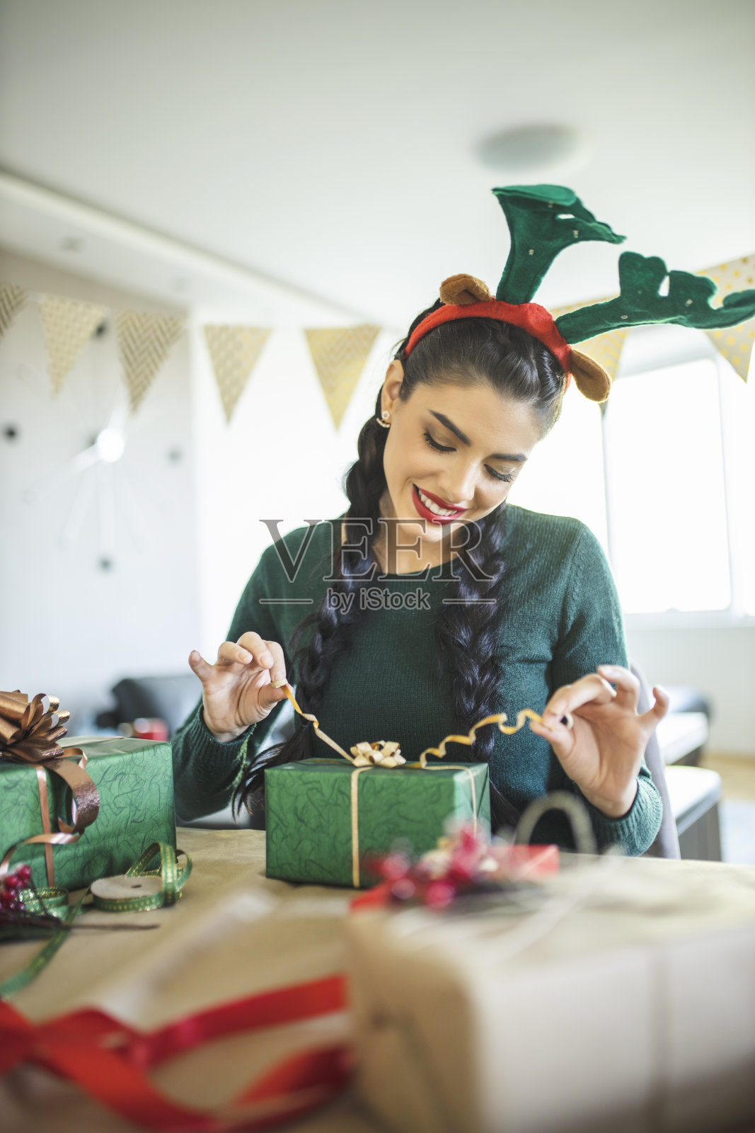 年轻漂亮的女人在家里包装和装饰圣诞礼物照片摄影图片