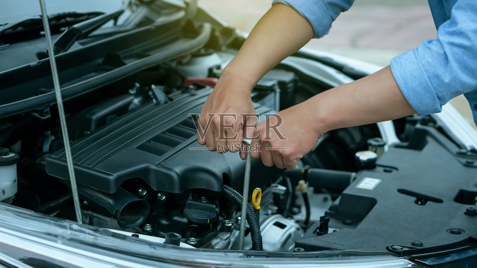 年轻人的手正在用扳手修理汽车工程师的概念和汽车修理照片摄影图片