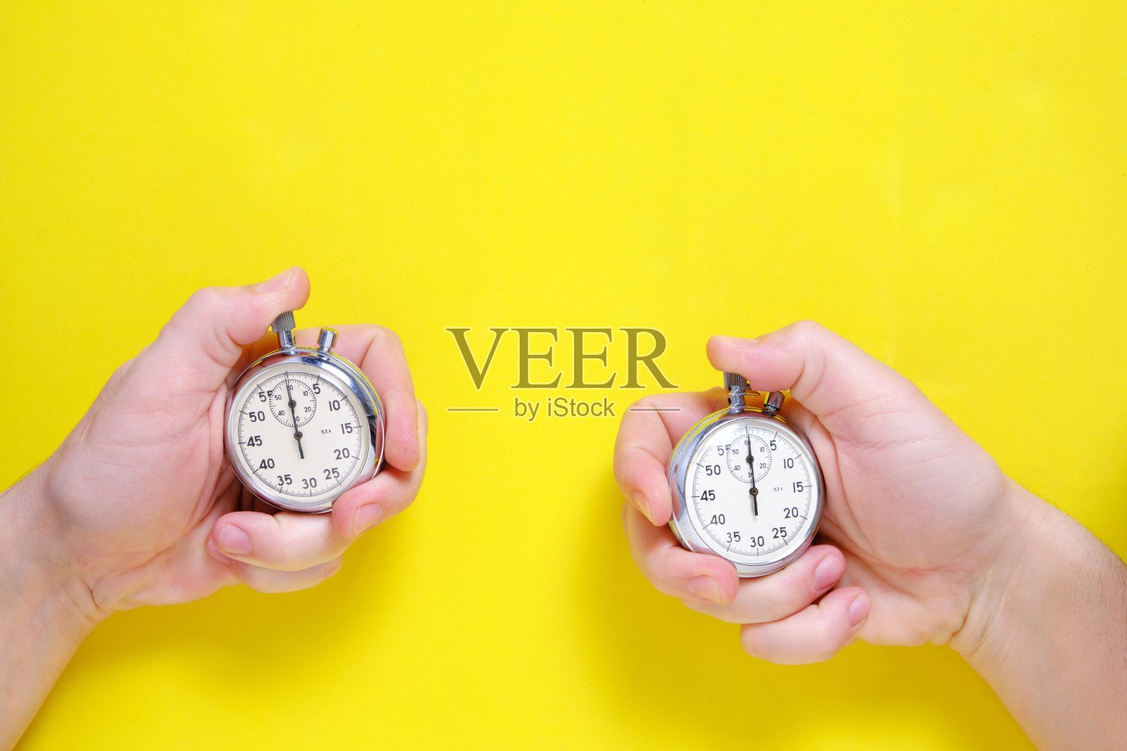 黄色背景上的机械秒表。照片摄影图片