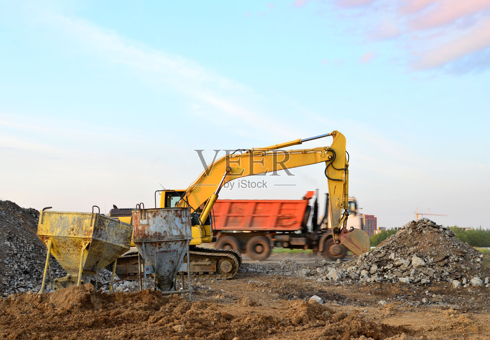 夕阳下建筑工地破碎混凝土和坚硬岩石的挖掘机照片摄影图片
