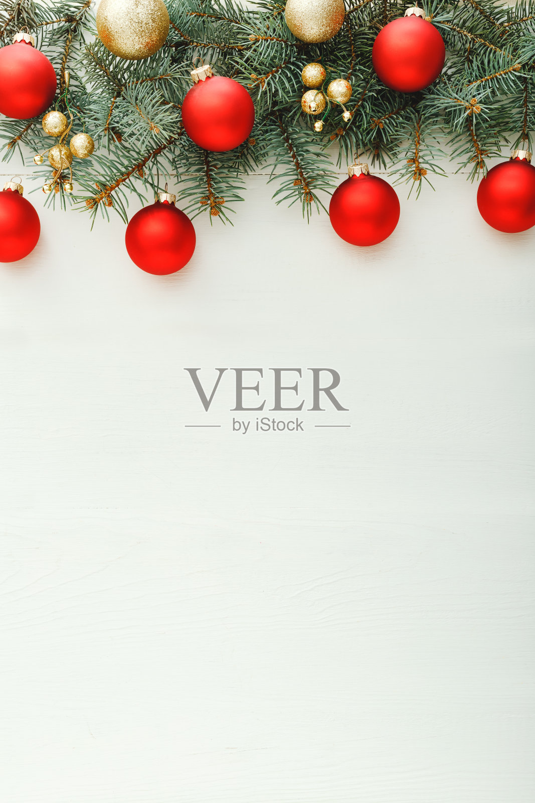 2020年的圣诞和新年庆祝图案组成由红色的球，杉木树枝在白色的木制背景。概念圣诞时间，冬天。平躺，俯视图，拷贝空间，Instagram故事照片摄影图片