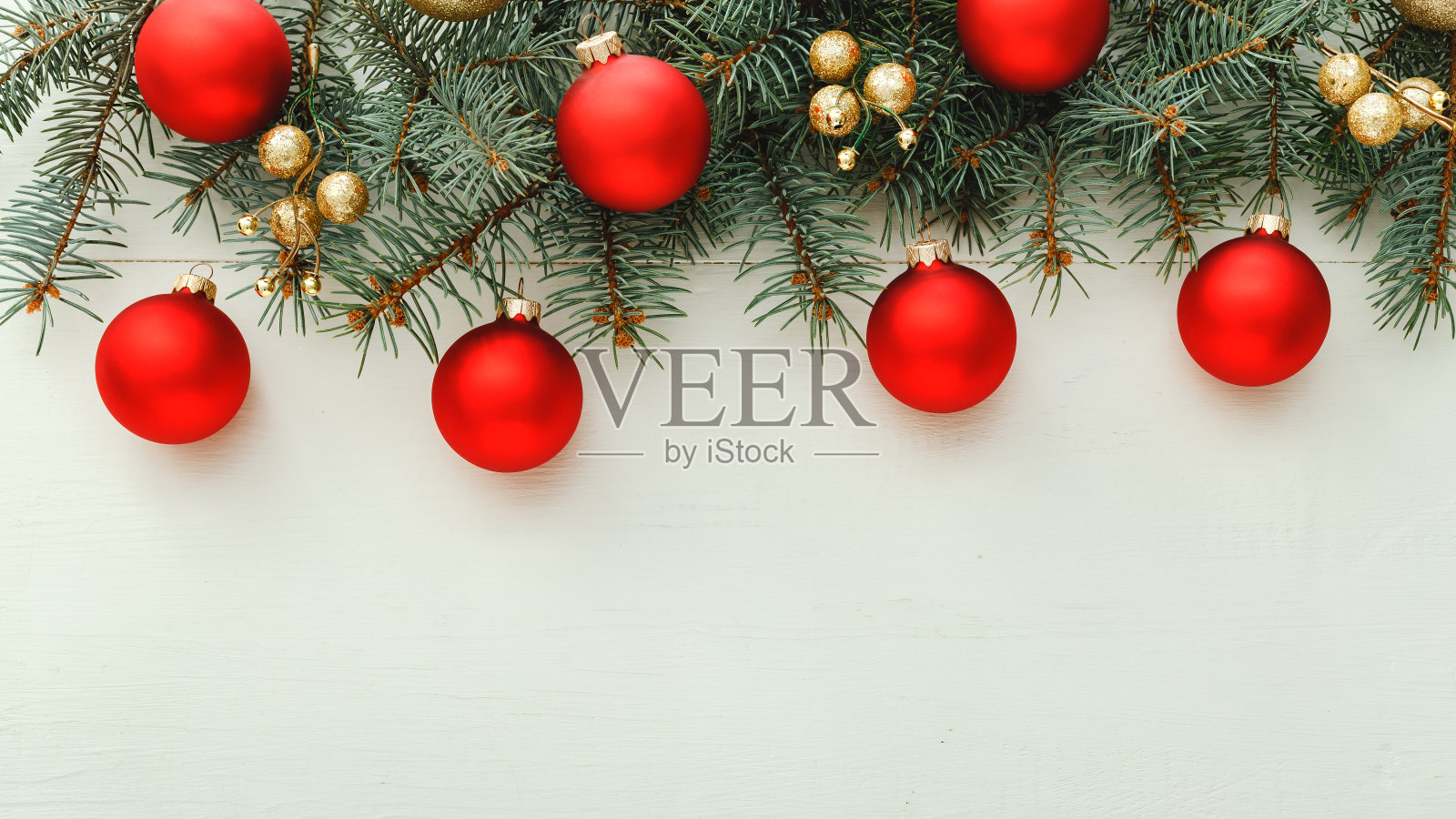 2020年的圣诞和新年庆祝图案组成由红色的球，杉木树枝在白色的木制背景。概念圣诞时间，冬天。平铺，俯视图，拷贝空间，长横幅格式照片摄影图片
