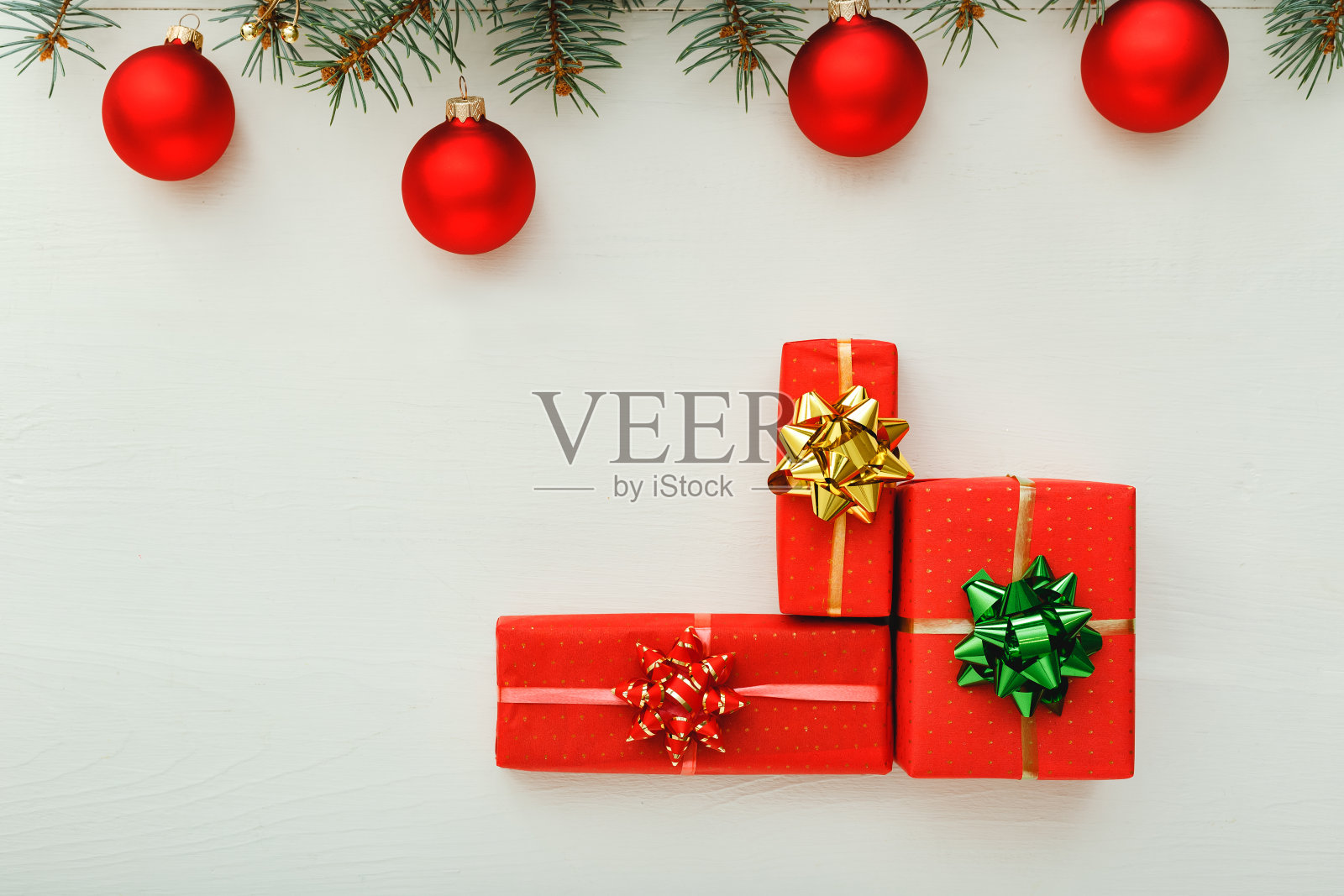2020年圣诞新年庆祝模式组成的红色礼品盒，杉木树枝，球在白色的木制背景。概念圣诞时间，冬天。平铺，俯视图，拷贝空间照片摄影图片