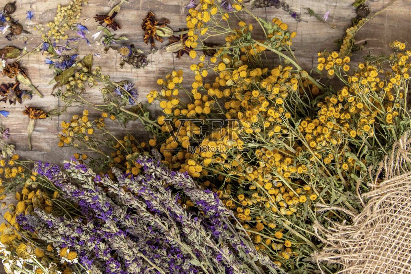 木桌上放着一束五颜六色的干野花照片摄影图片