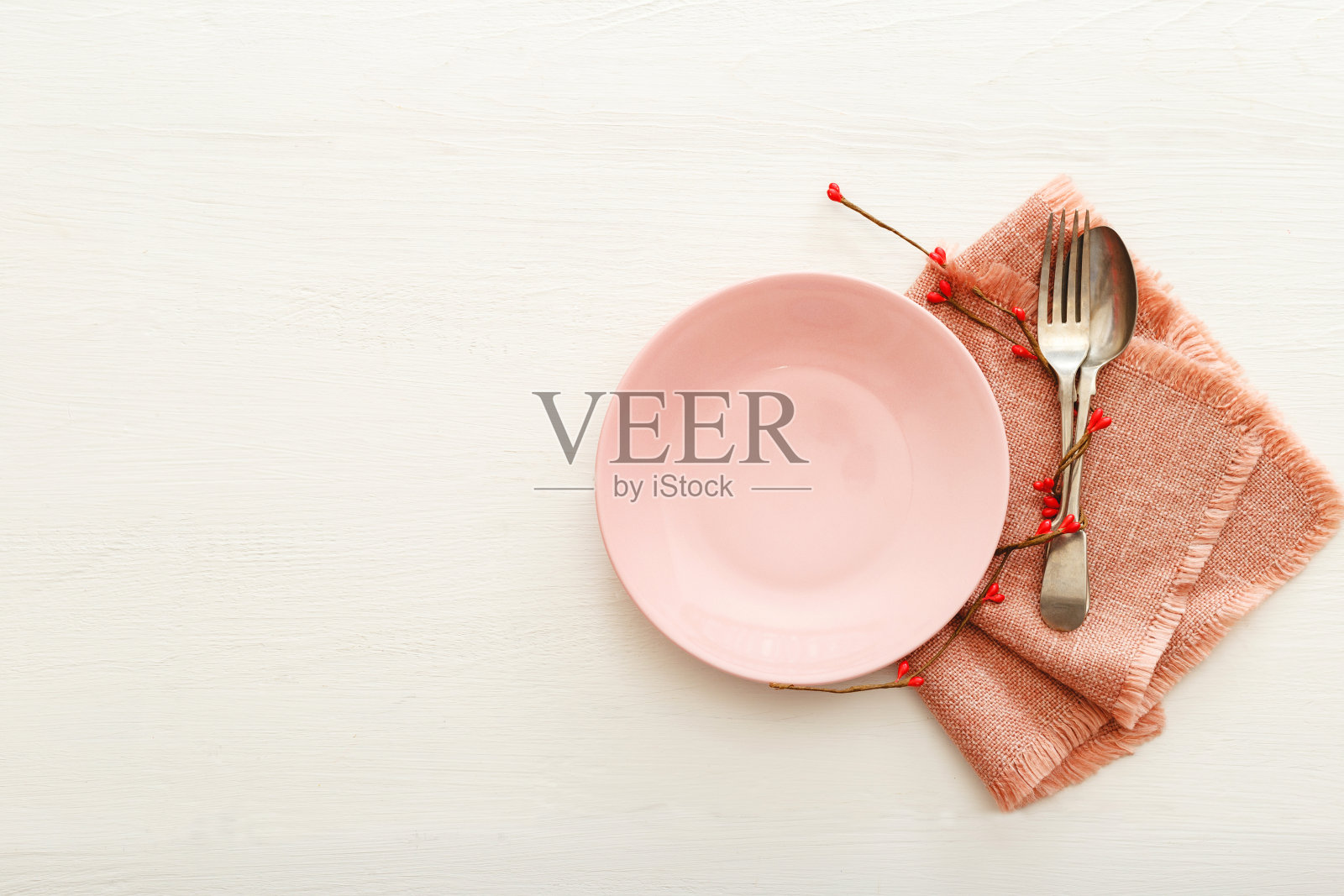 情人节的餐桌上摆放着一张白色的木桌。情人节在餐厅用餐。粉红色盘子上有两颗红心。情人节，爱情，浪漫，约会概念，拷贝空间，平躺照片摄影图片