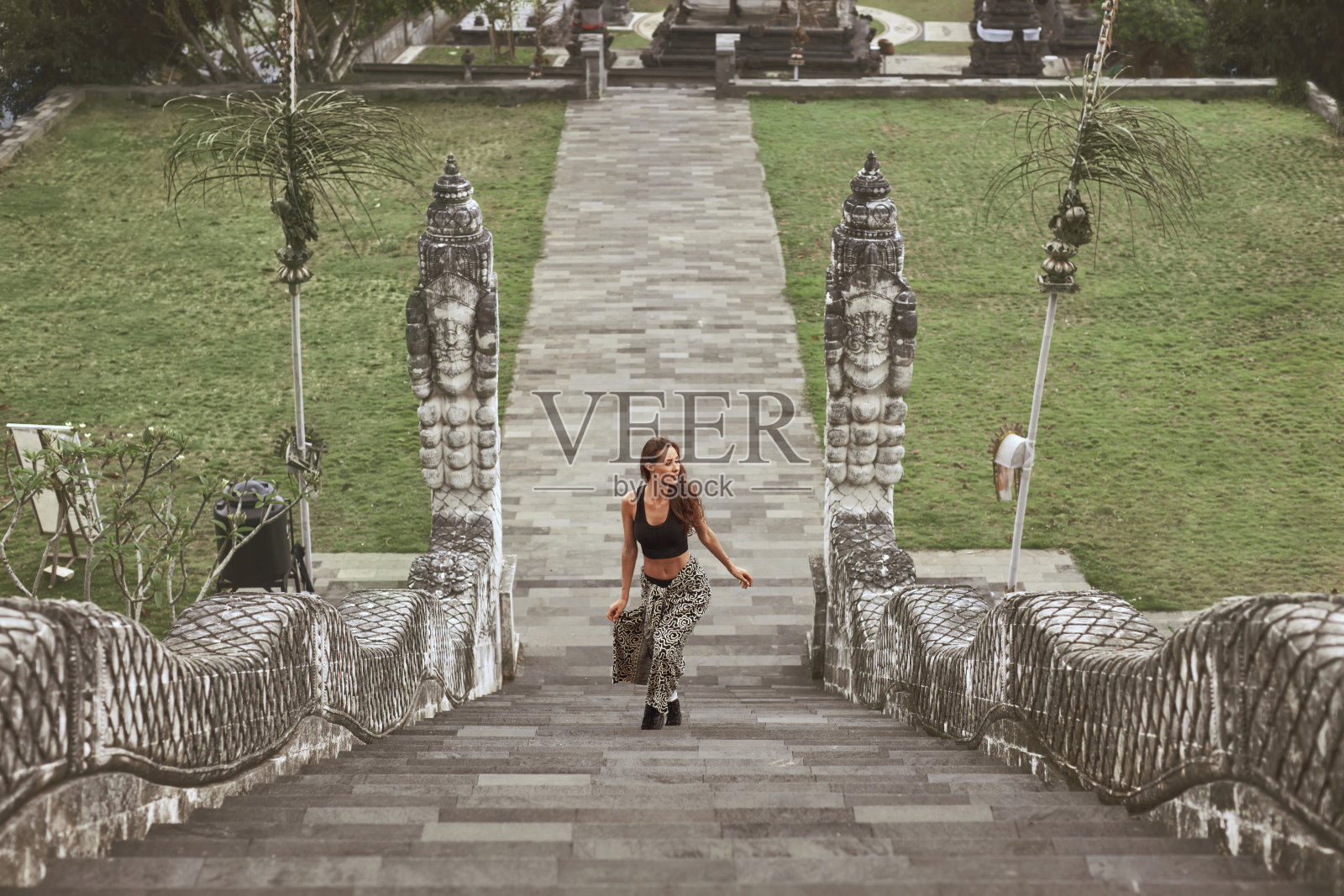 美丽的女孩爬上Pura Lempuyang寺庙的石头楼梯，印度尼西亚巴厘岛。年轻女子探索Karangasem的古代建筑。照片摄影图片
