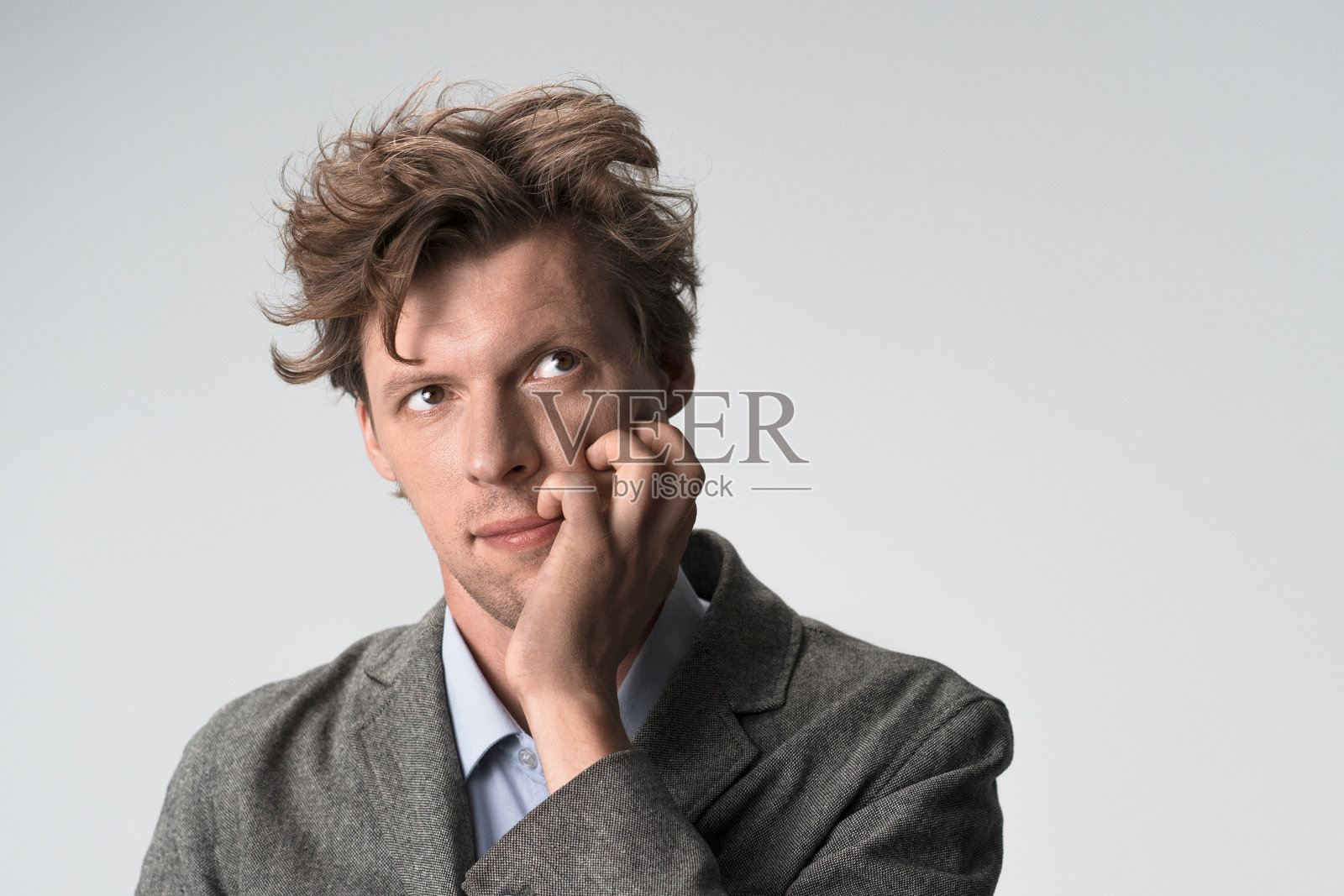 深思熟虑的人抬起头，侧过身去，用手抓着自己的脸。本空间照片摄影图片